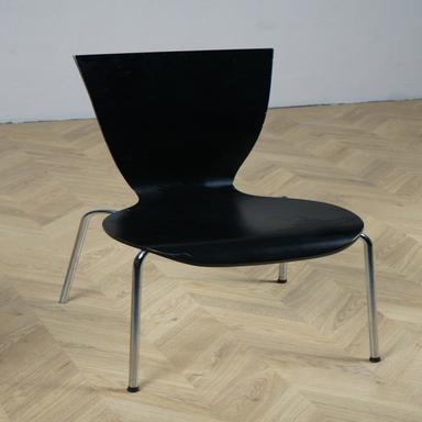 Sort stabelbar mødestol i lakeret træ med brugsspor set i skrå vinkel – enkel og robust design.